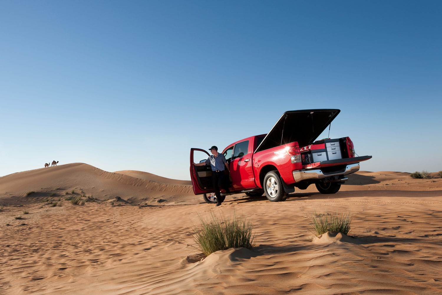 Czerwony pick-up z systemami modułowymi na pustyni